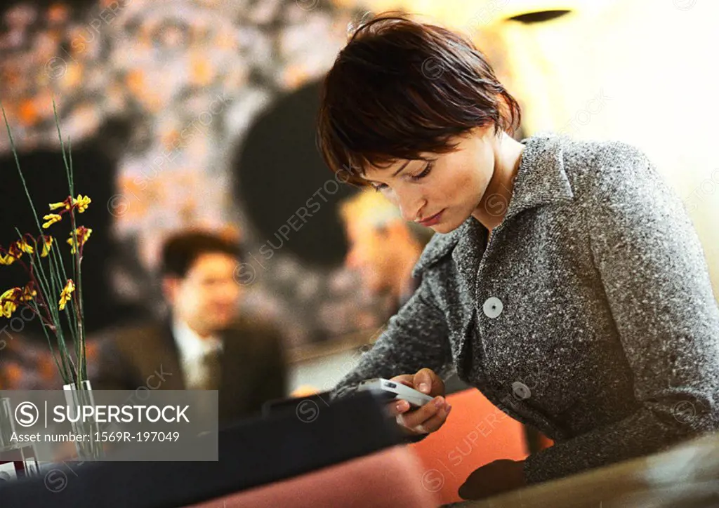 Businesswoman sitting, dialing cell phone