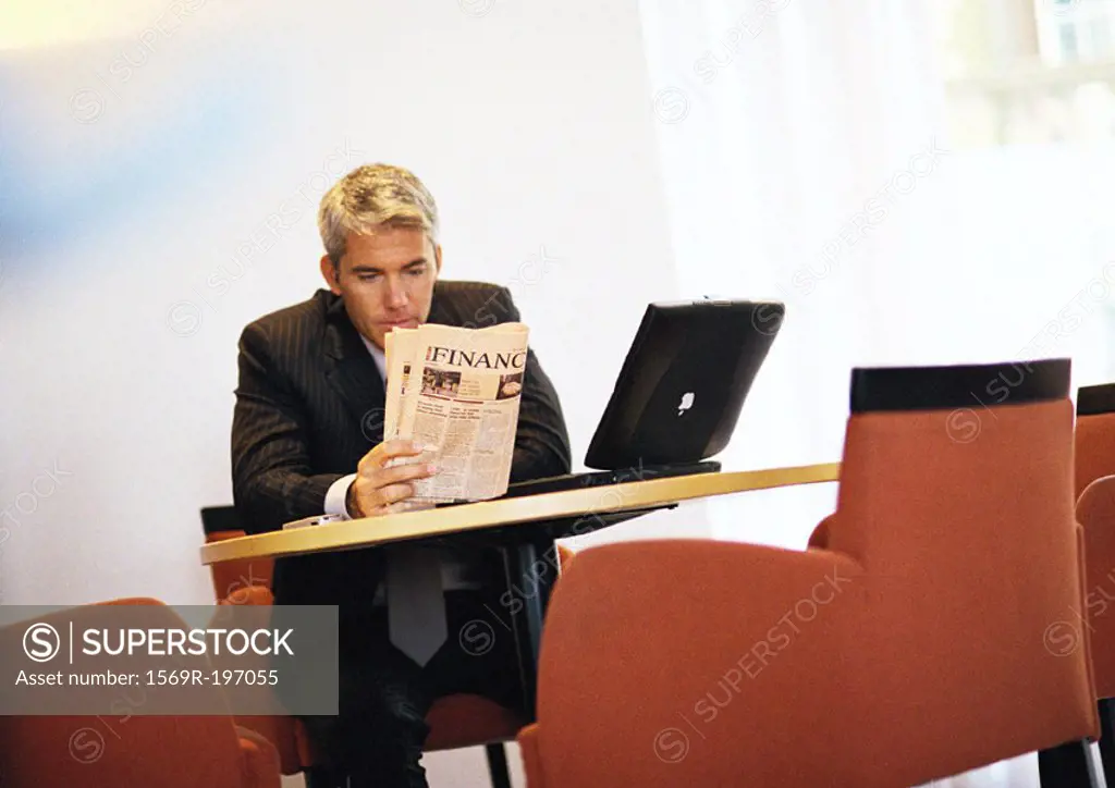 Businessman sitting reading paper