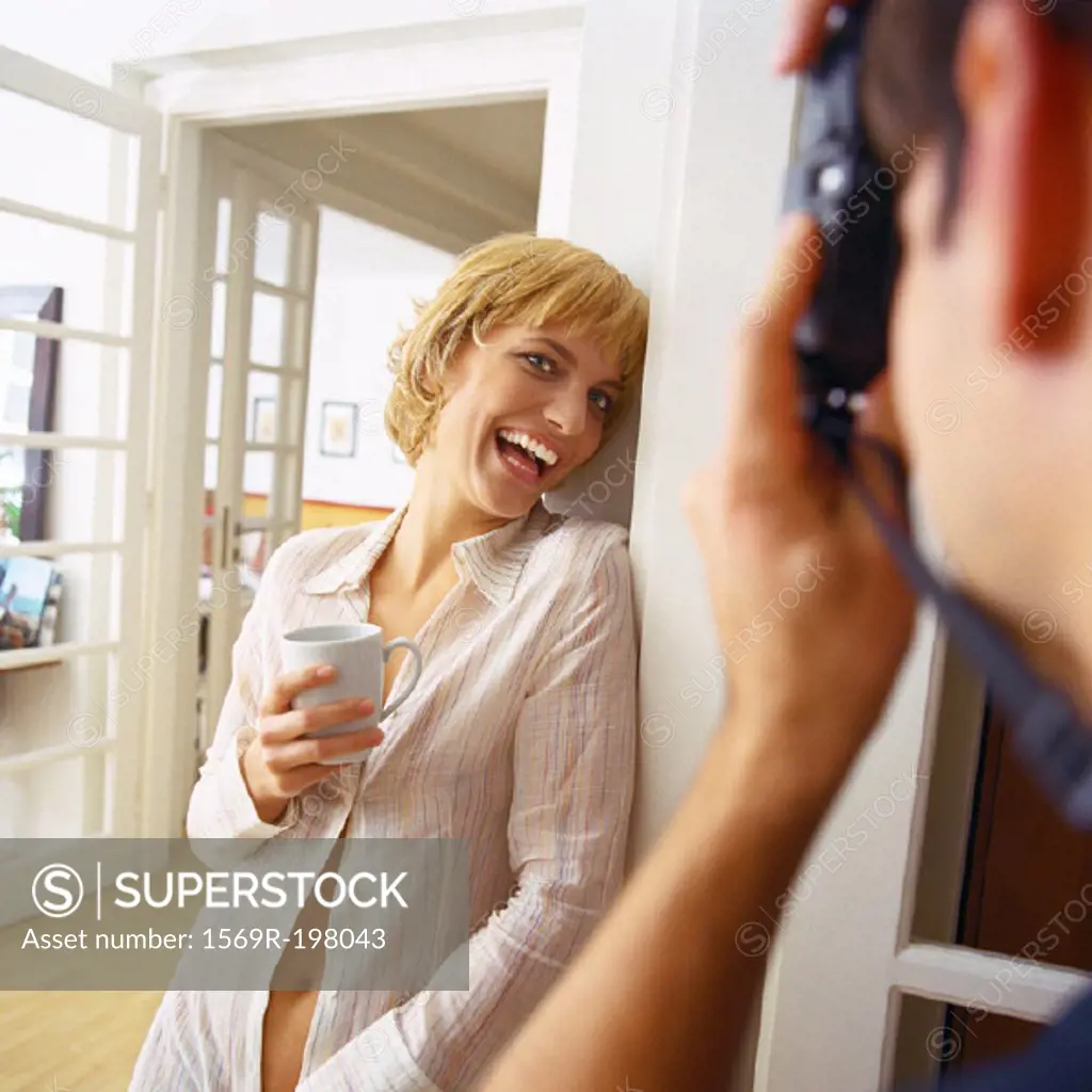 Young woman smiling while being photographed by man
