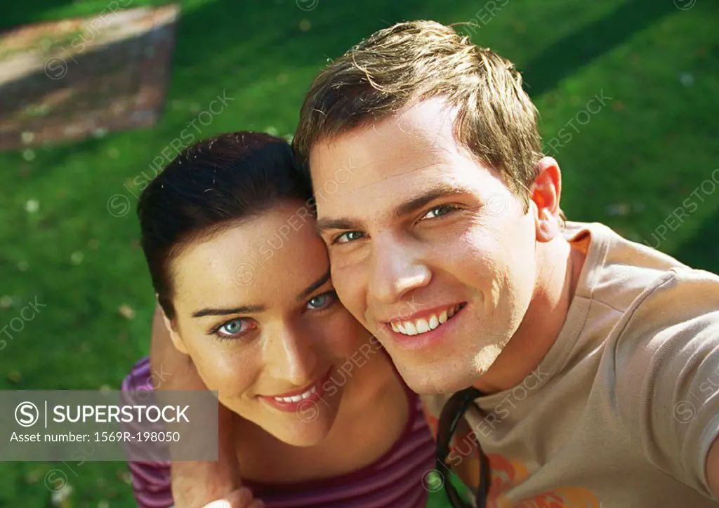 Man´s arm around woman´s shoulder, looking up and smiling