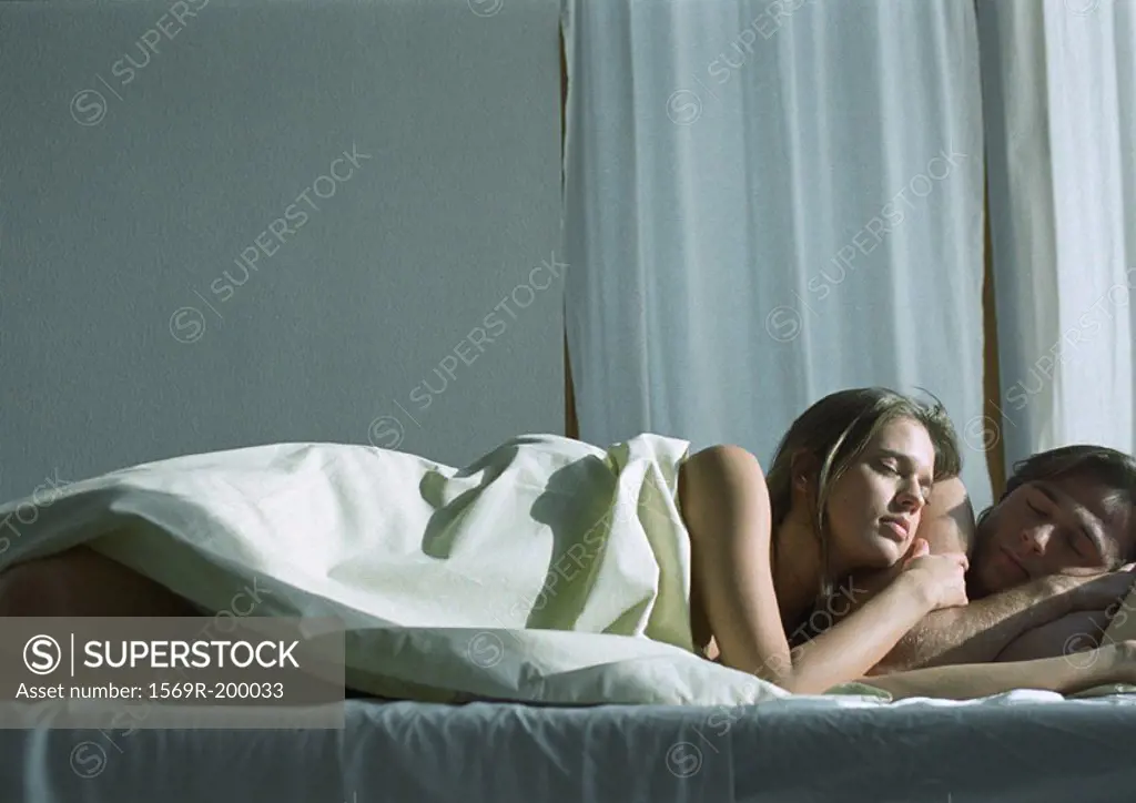 Man and woman in bed, woman leaning against man
