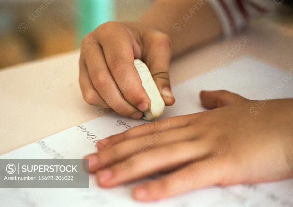 Hands holding eraser on notebook