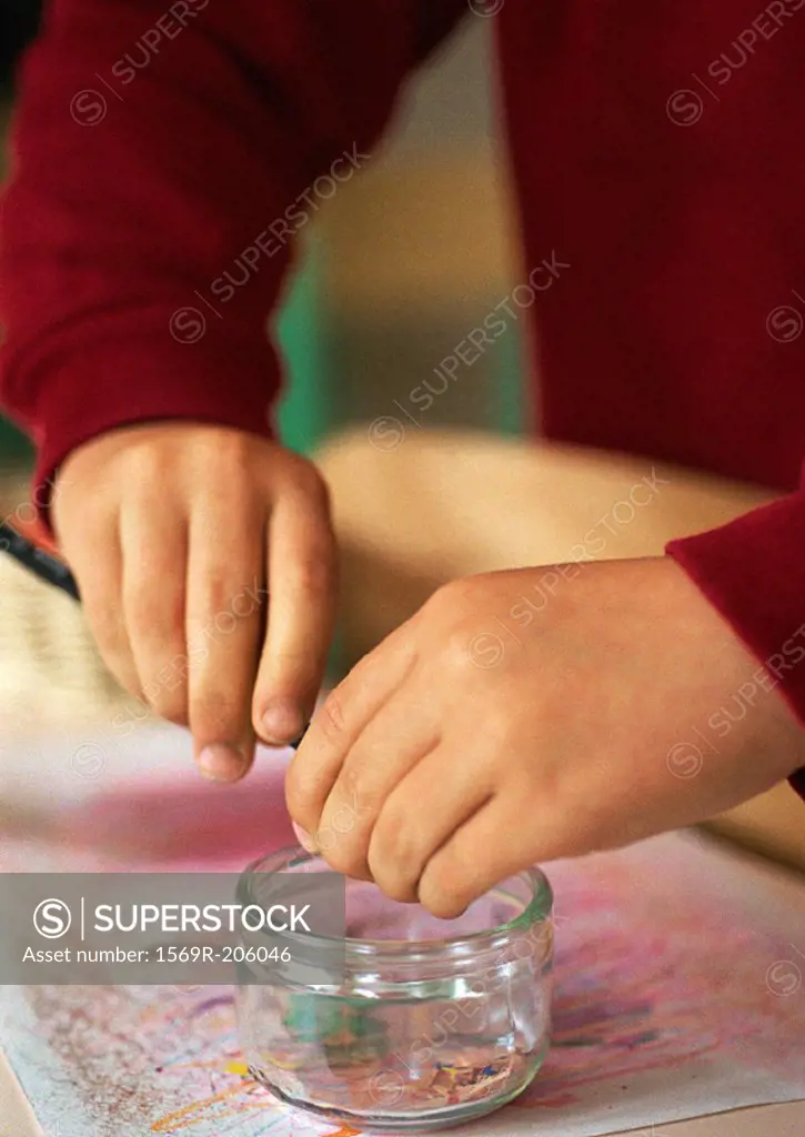 Children´s hands sharpening pencil