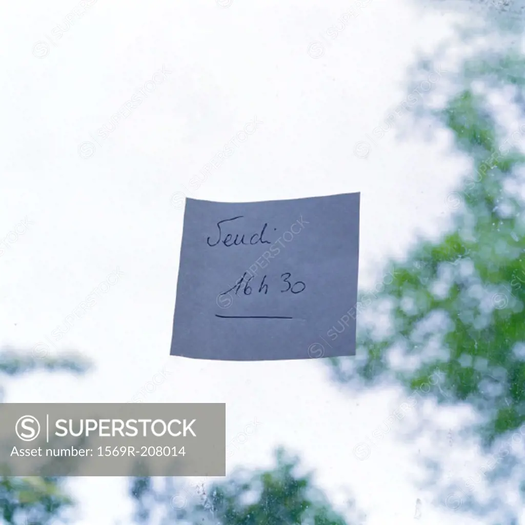 Adhesive note on pane of glass, close-up