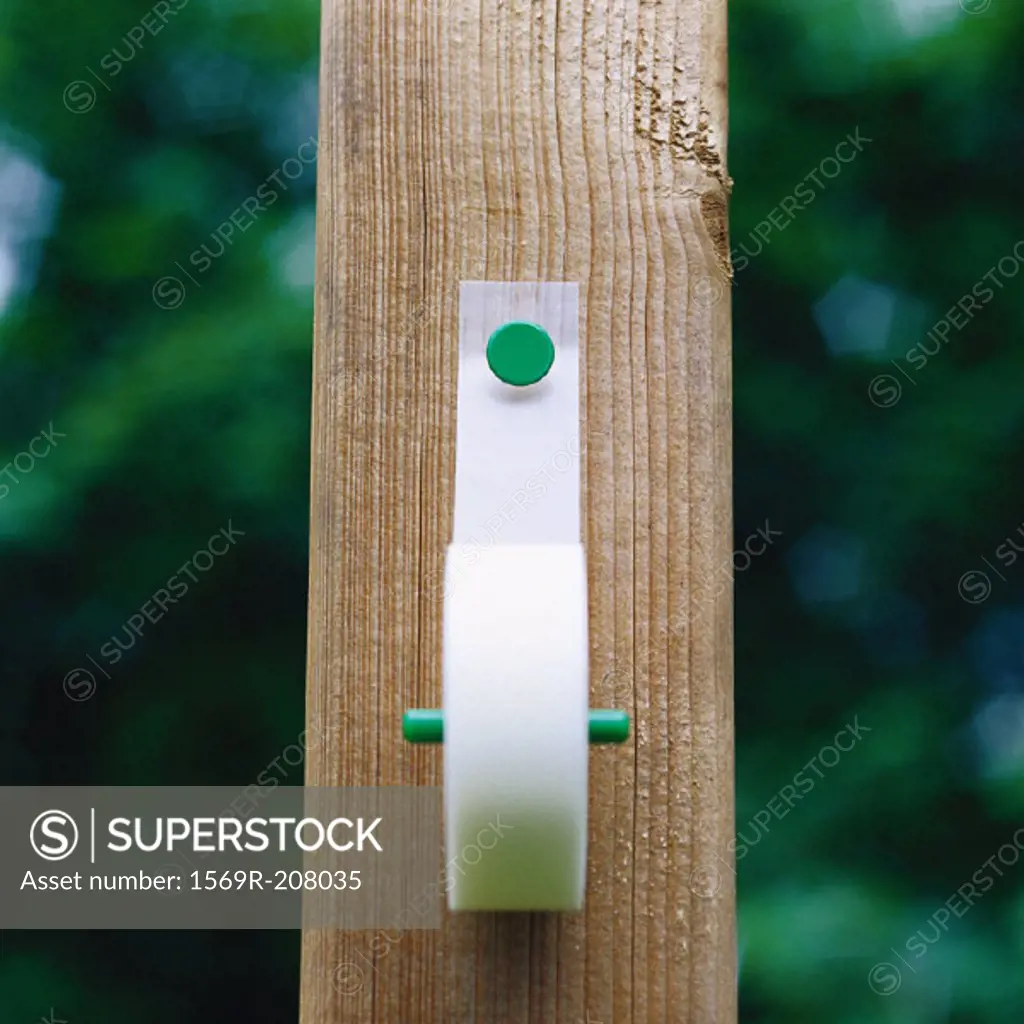Adhesive tape tacked onto fence post
