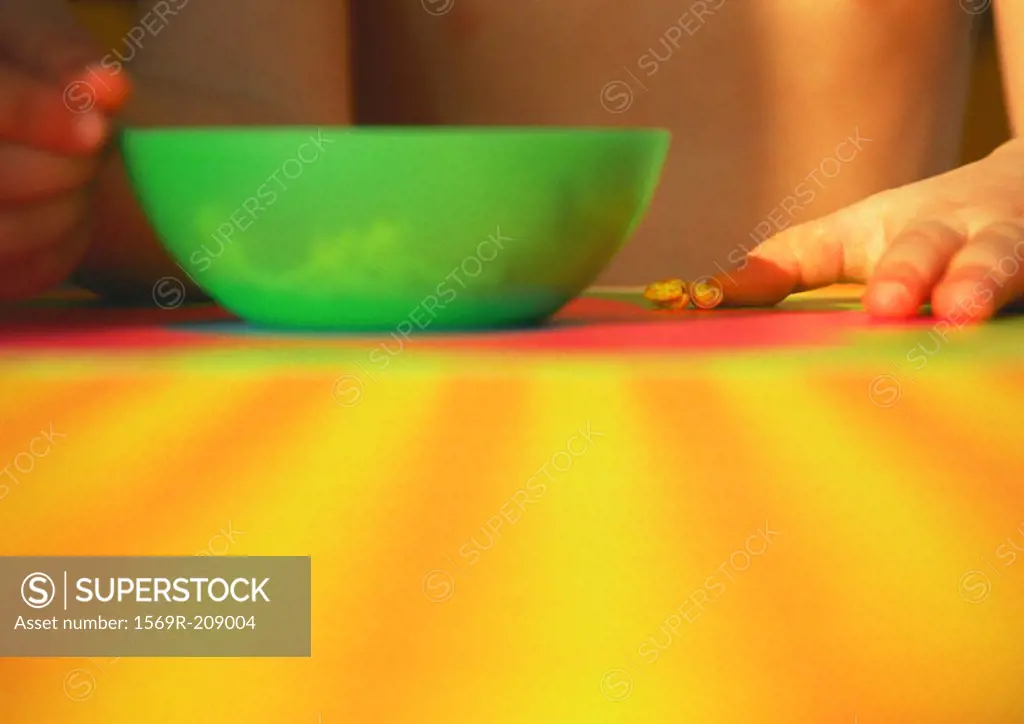 Green bowl on a table, child in background