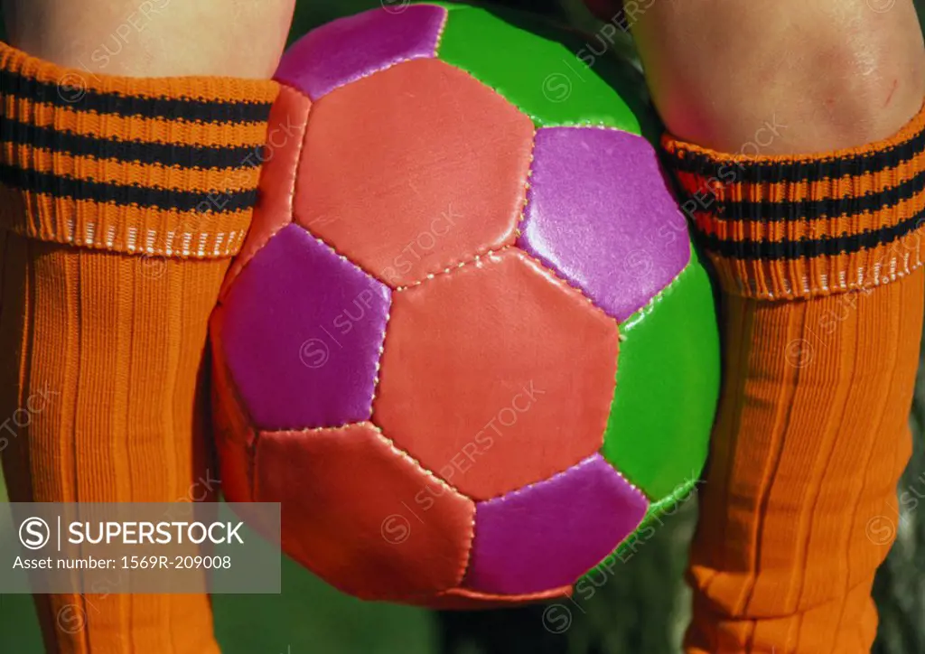 Soccerball between legs, close up