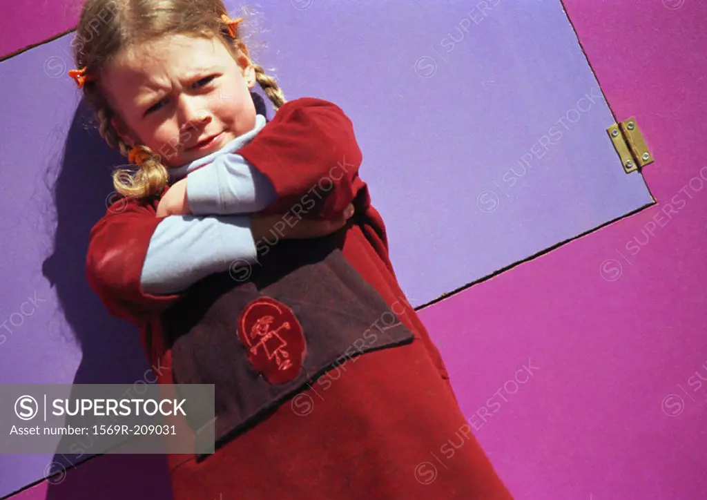 Little girl frowning and crossing arms