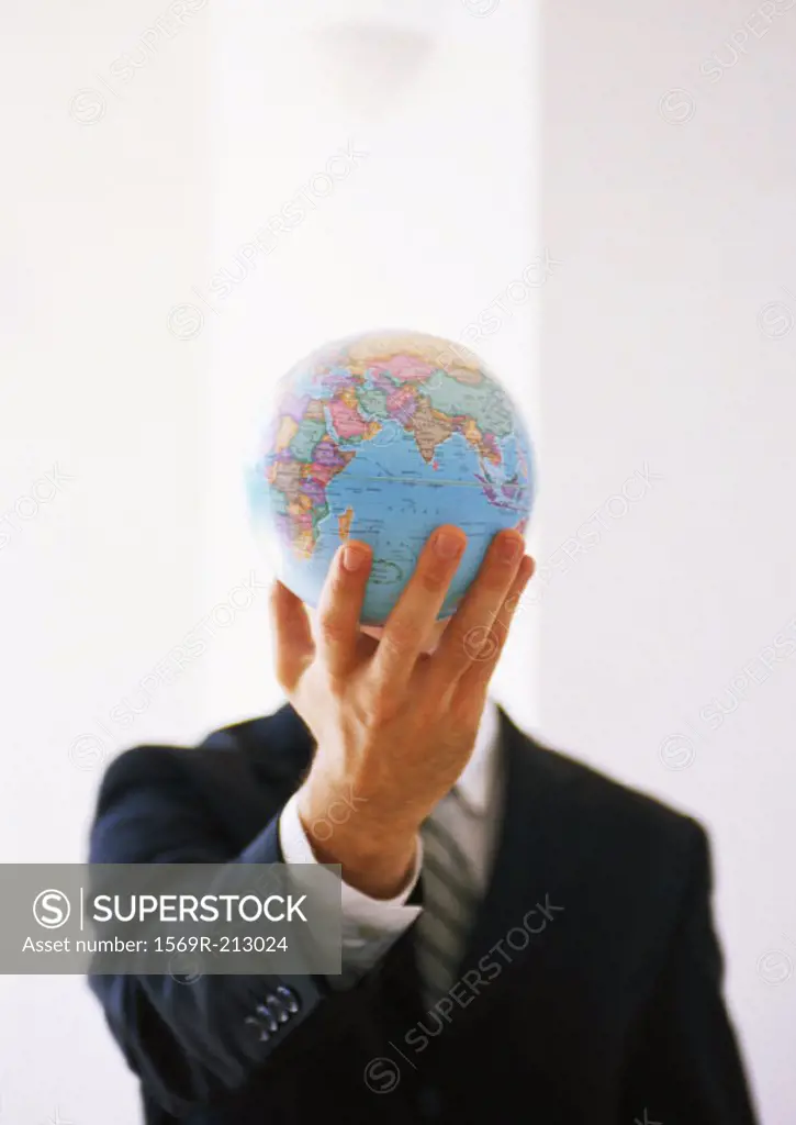 Businessman holding out globe, hiding man´s face