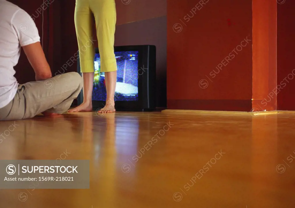 Couple in front of television on floor, surface level view
