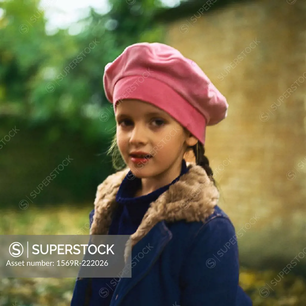 Girl outside wearing hat and coat, looking at camera