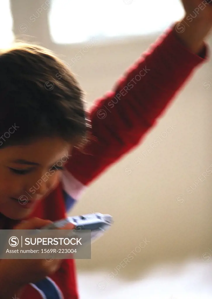 Young boy playing video game, close up, blurred