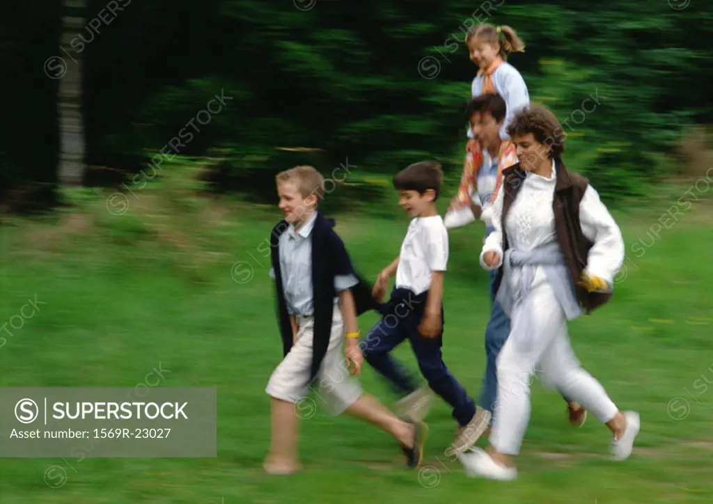 Family running together outside, blurred