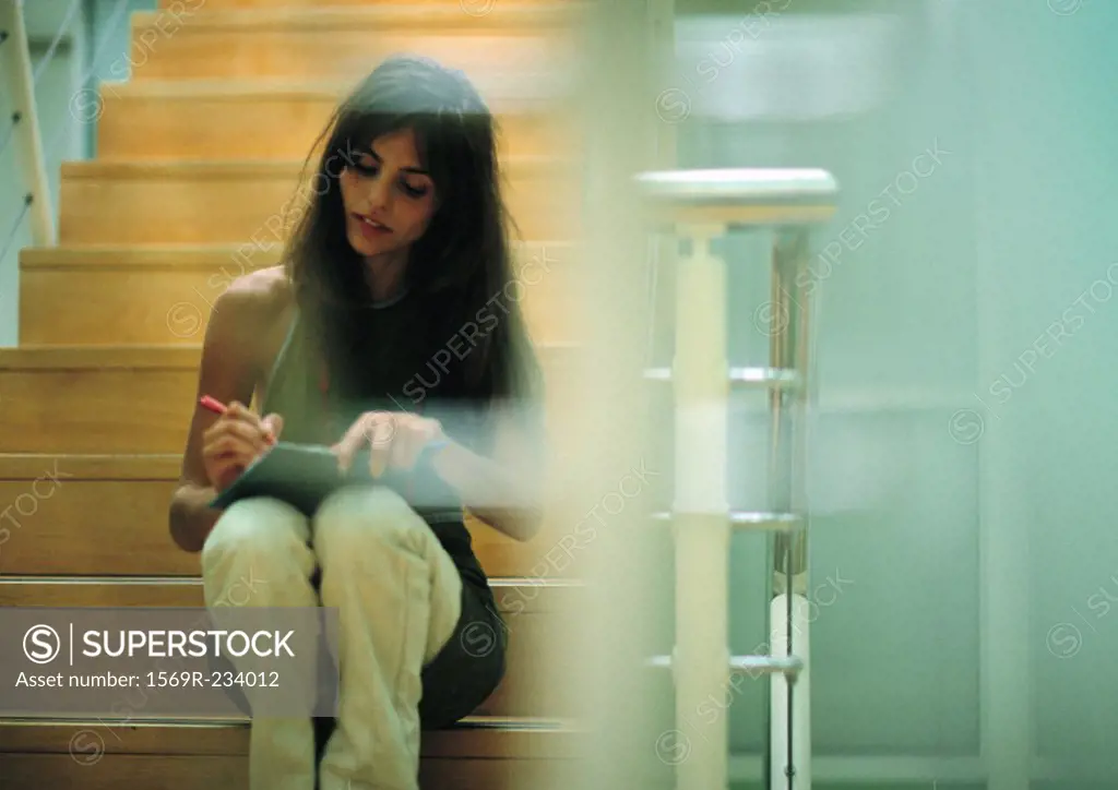 Woman sitting on stairs writing