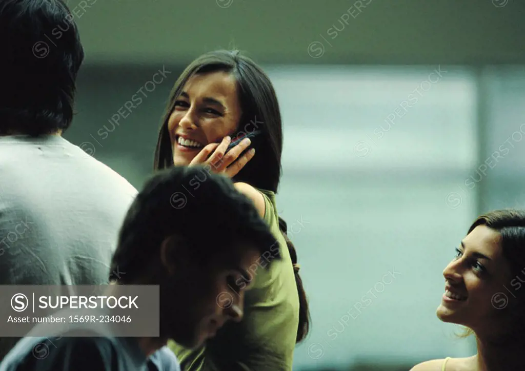 Woman talking on cellphone in group of people