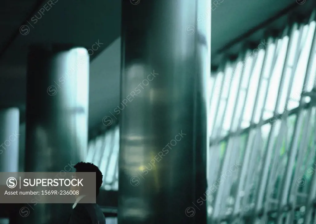 Businessman standing between two large metal columns