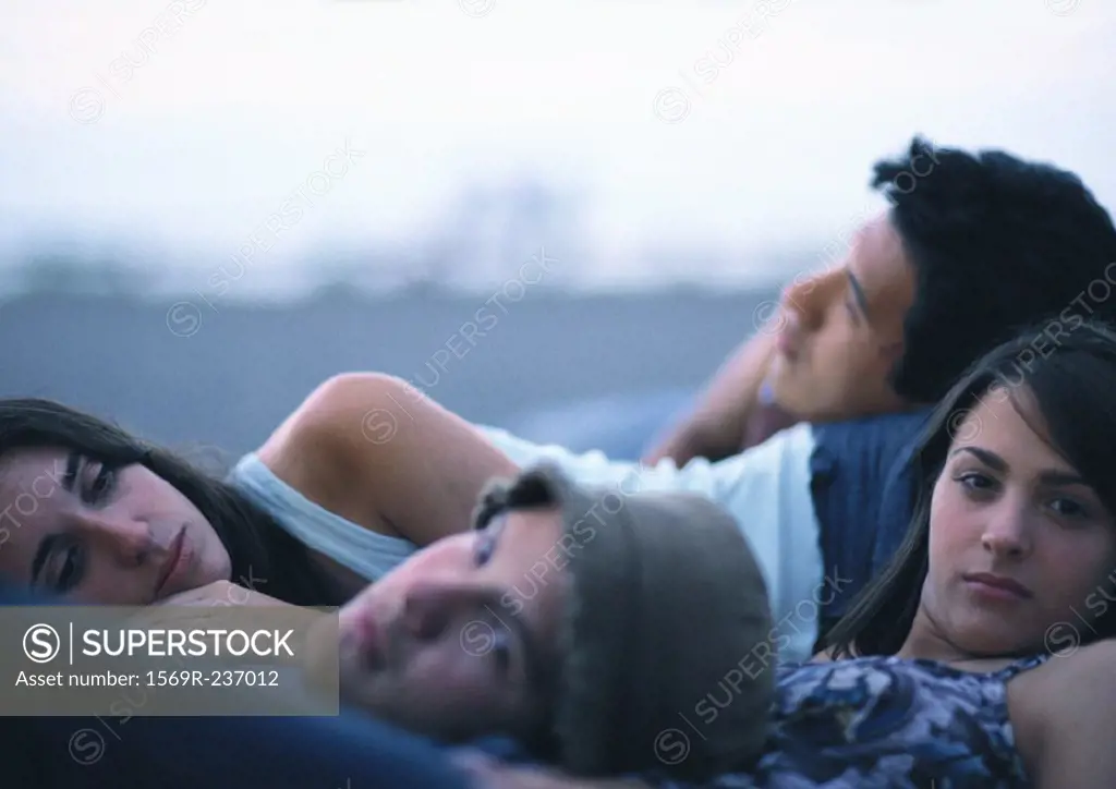 Young people lying together outdoors