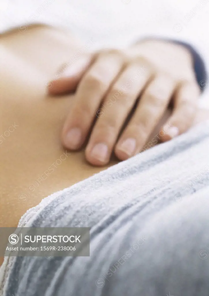 Woman´s hand on bare stomach, close-up