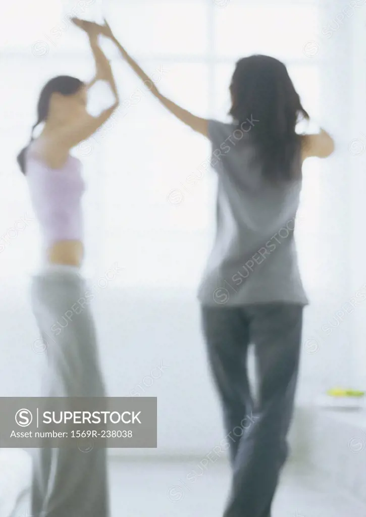 Two young women dancing, blurred