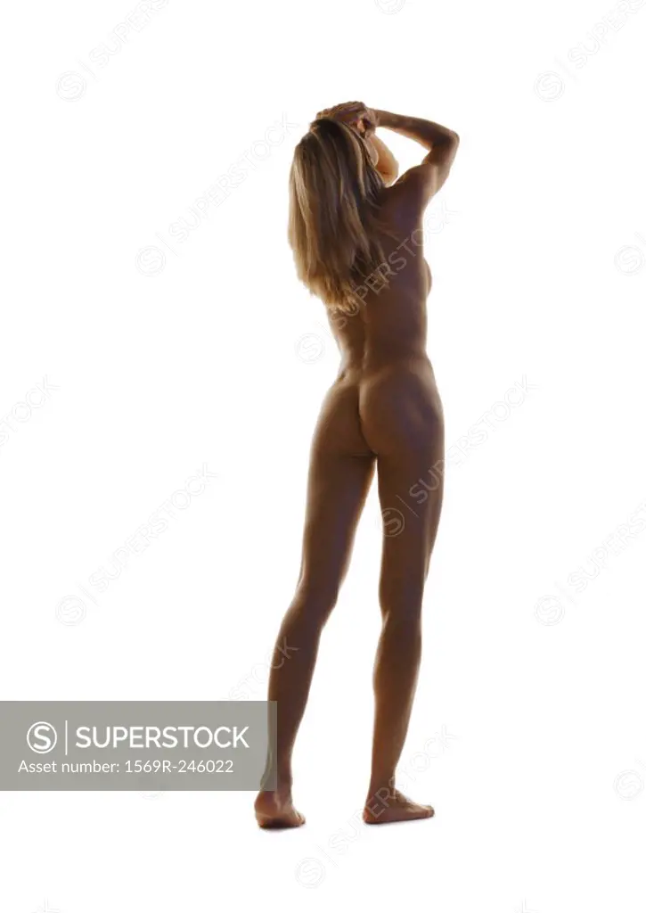 Nude woman standing with hands on head, full length, rear view