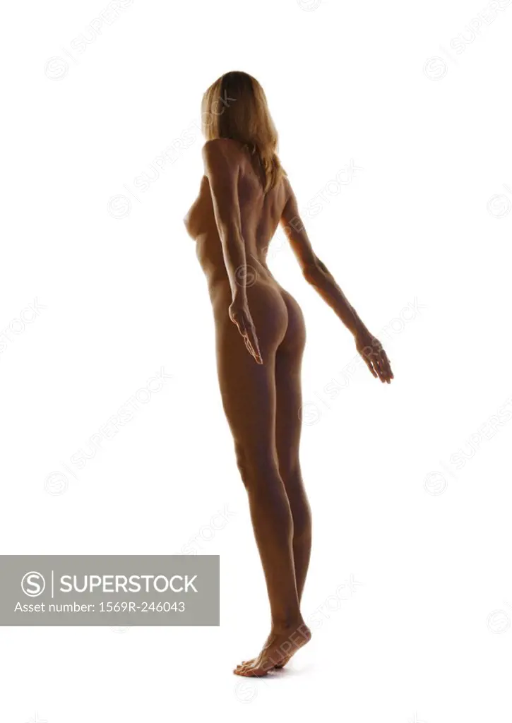 Nude woman standing with arms back, full length
