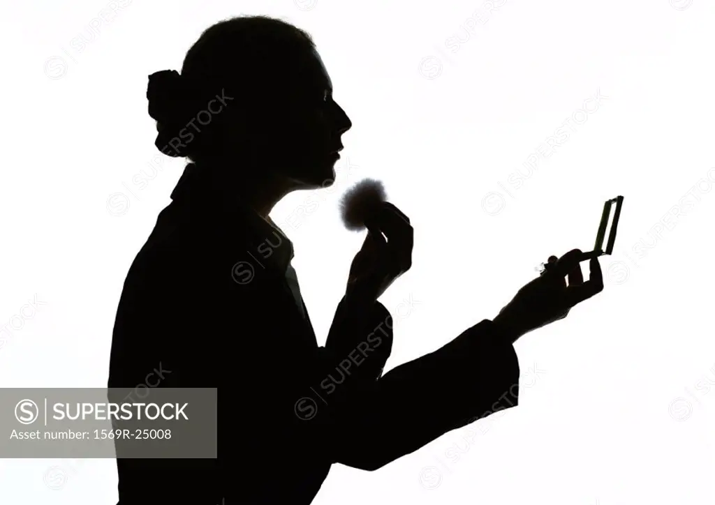 Woman applying makeup, silhouette