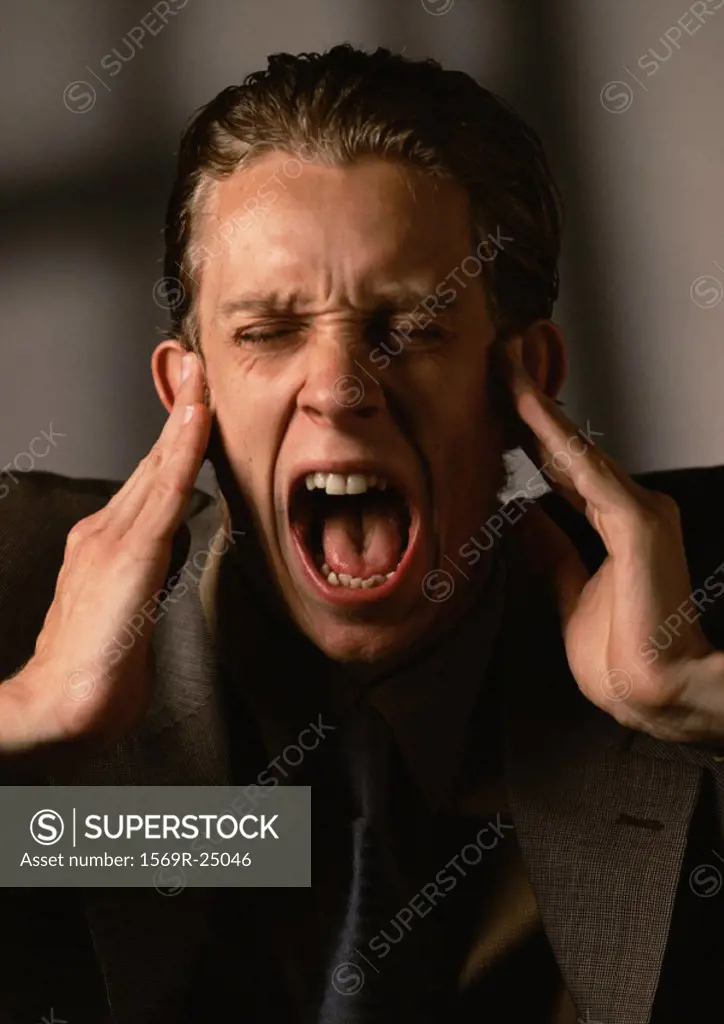 Man covering ears and screaming