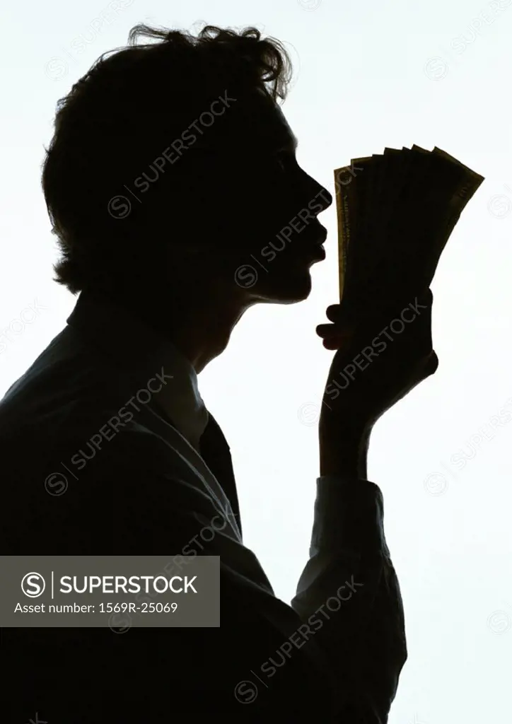 Man kissing money, silhouette
