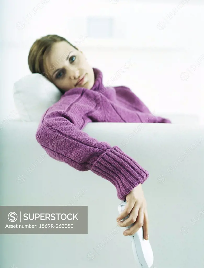 Woman sitting on sofa, holding cell phone
