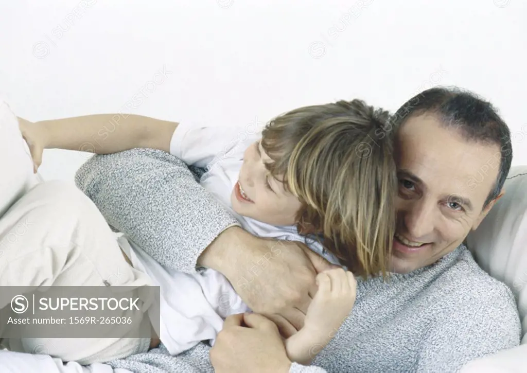 Father holding son in arms, laughing