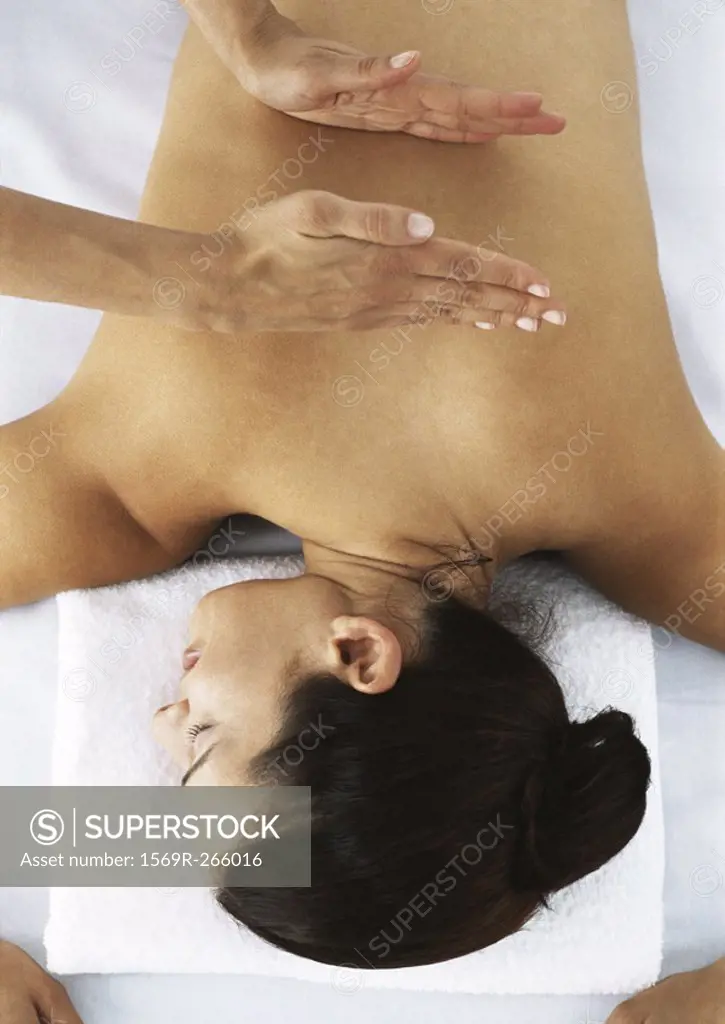 Woman lying on massage table being massaged, high angle view