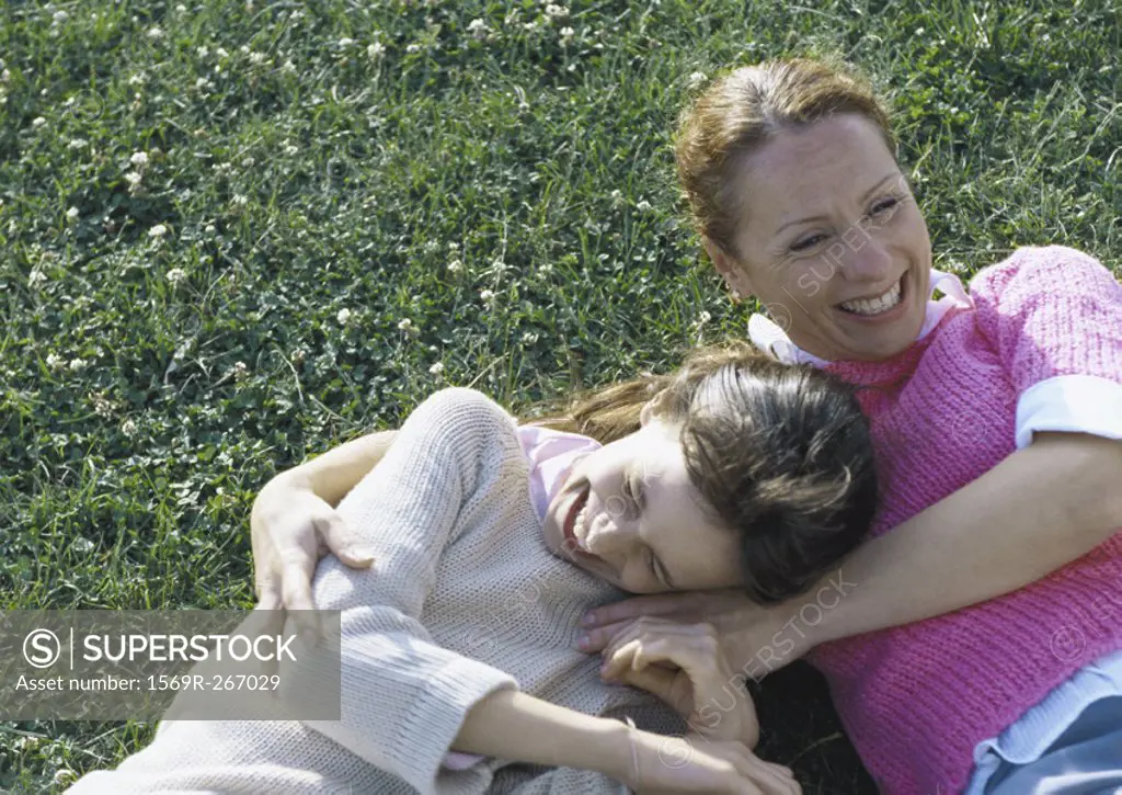 Woman and daughter lying on grass laughing