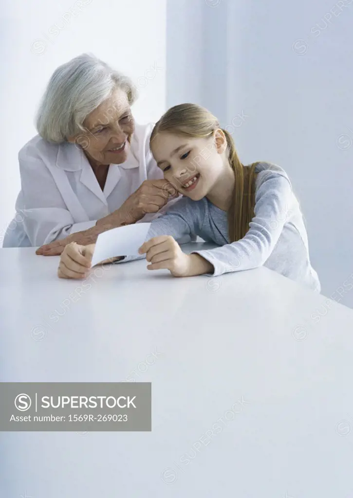Grandmother and girl looking at photo