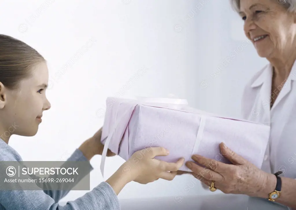 Girl giving package to grandmother