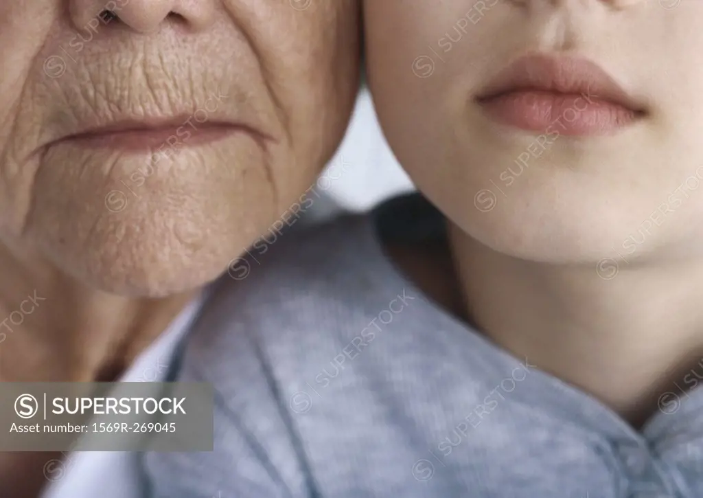 Girl and grandmother, cheek to cheek, close-up, partial view