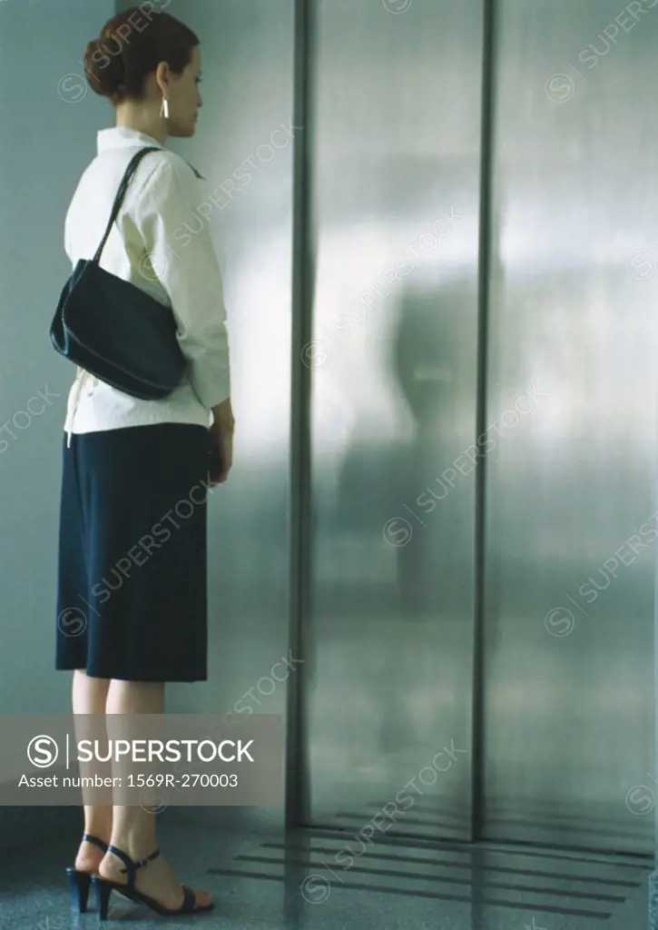 Woman waiting for elevator, full length