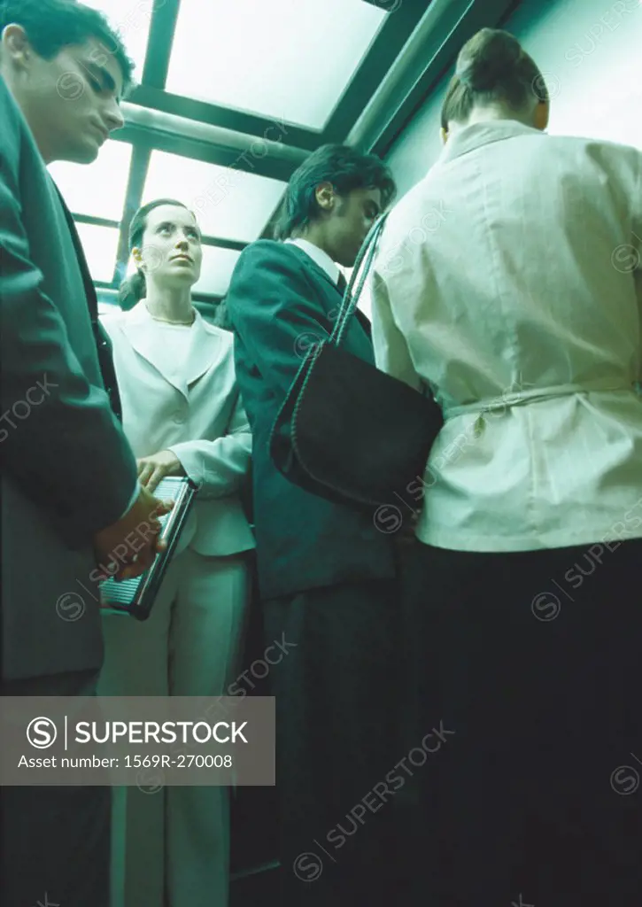 Businesspeople in elevator, low angle view