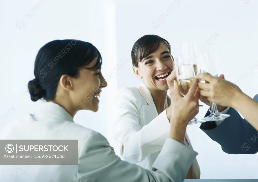 Businesspeople clinking glasses and smiling