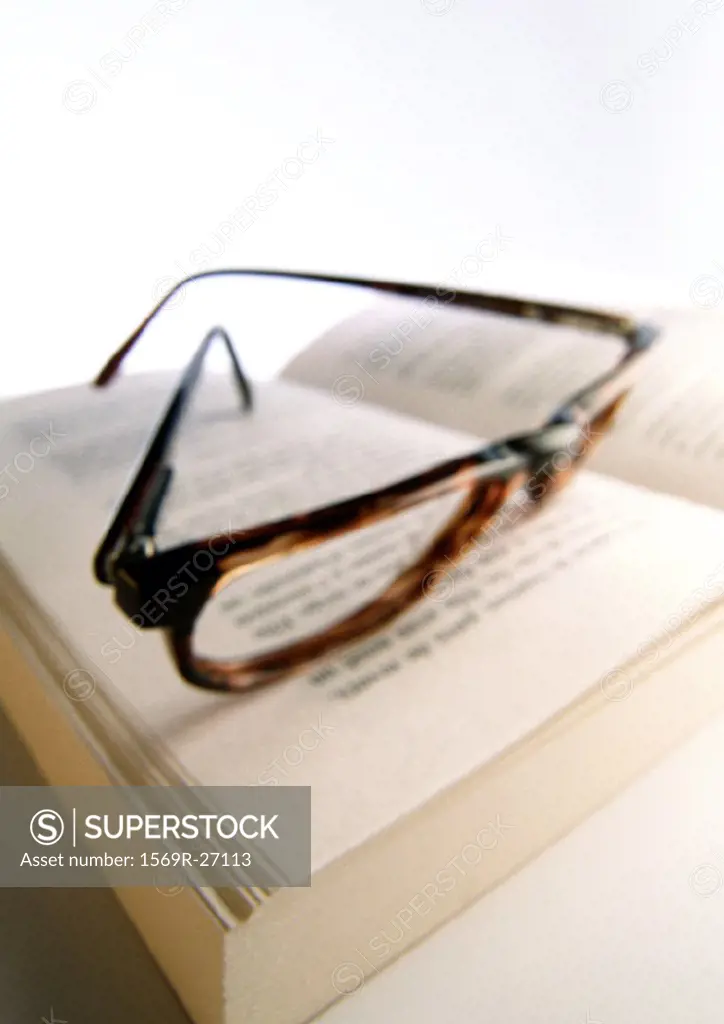 Glasses laying on open book, close-up