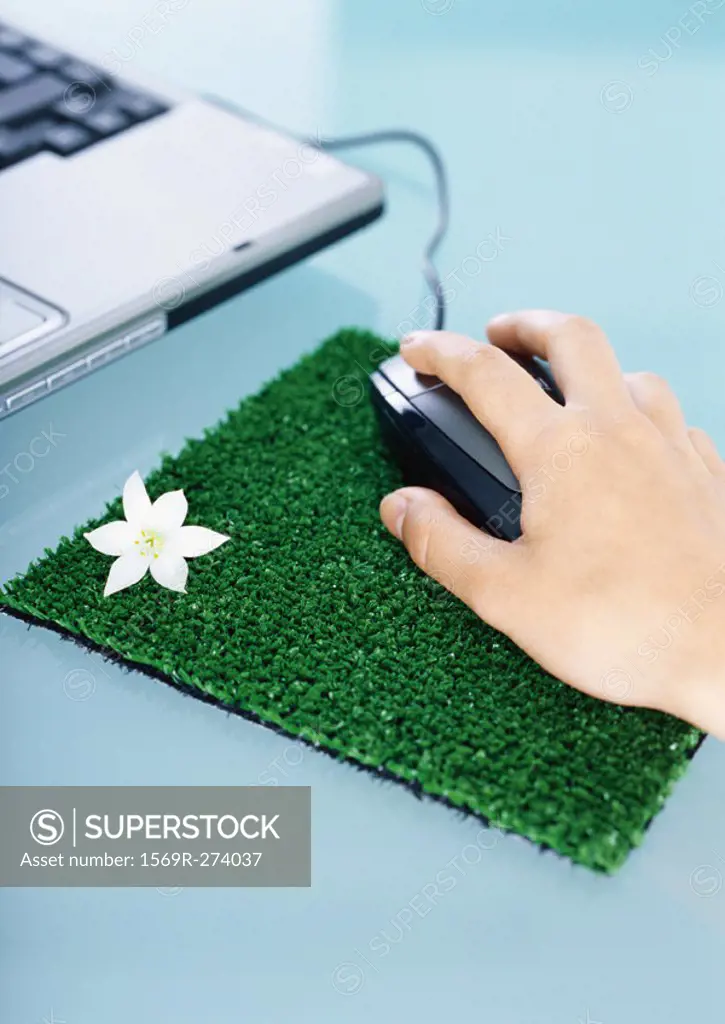Hand using mouse on mouse pad made of artificial turf