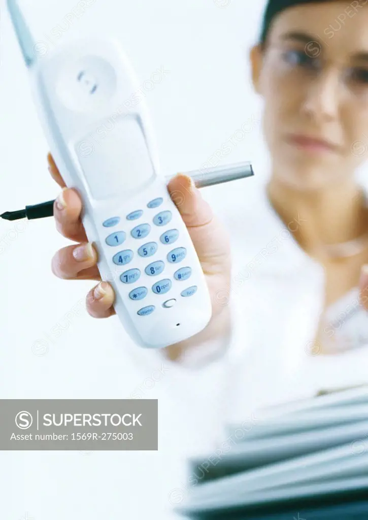 Woman holding out cordless phone