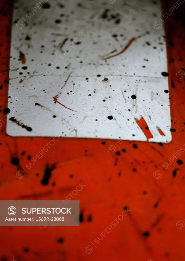 Black splatters on white and red plastic