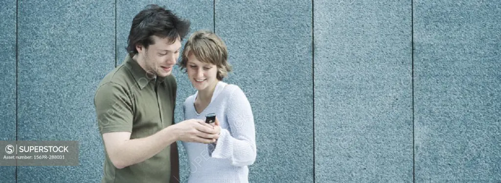Young couple looking at camera phone