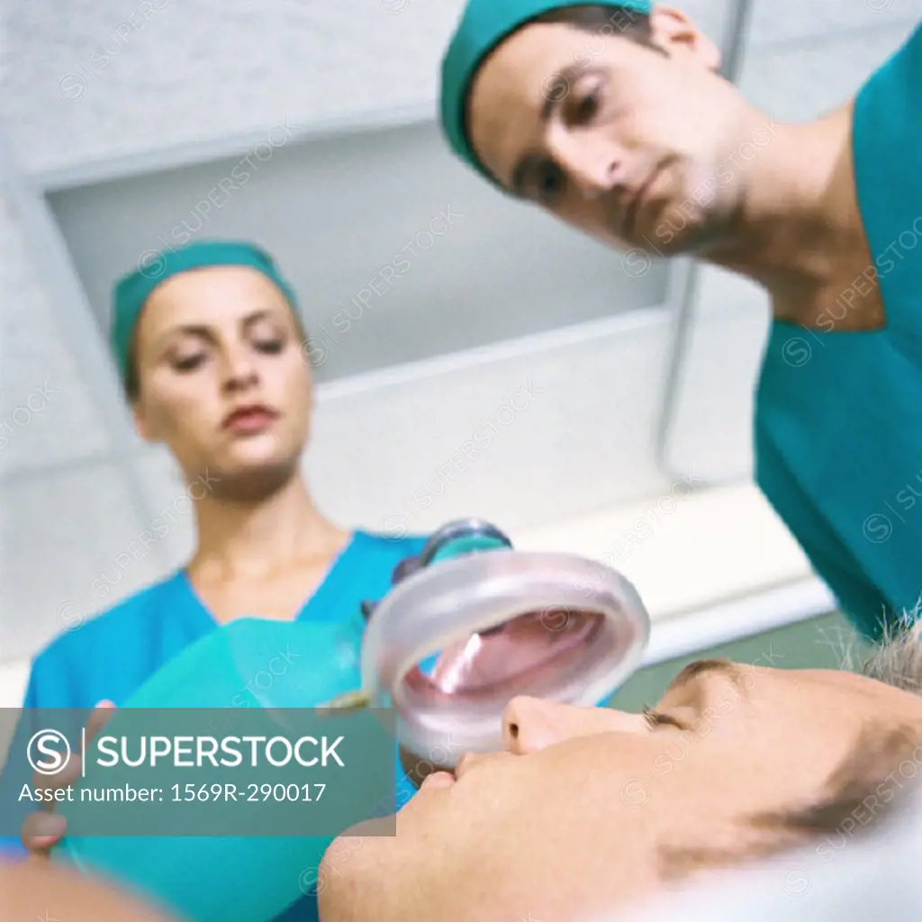 Doctors placing oxygen mask over patient´s face