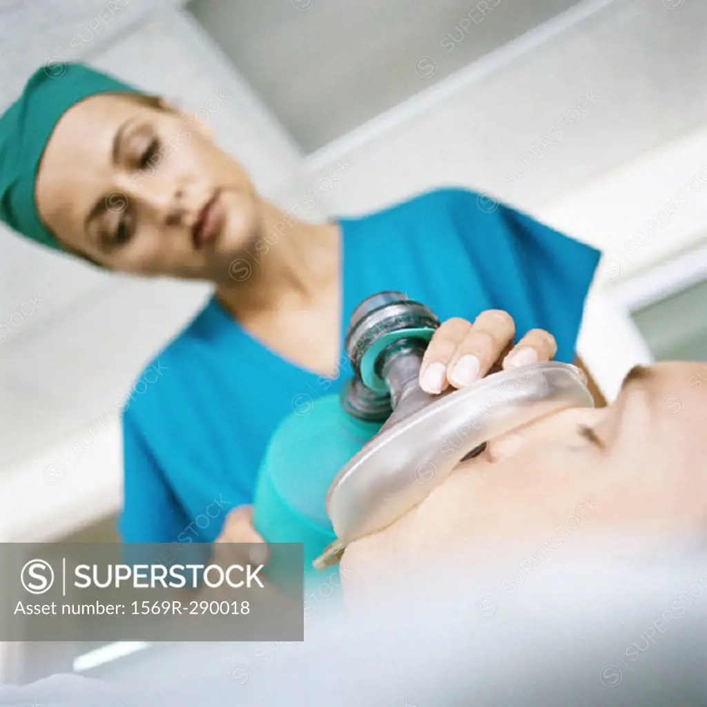 Female doctor holding oxygen mask over patient´s face