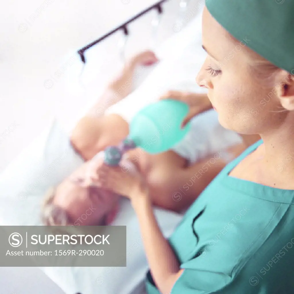Female doctor holding oxygen mask over patient´s face, high angle view