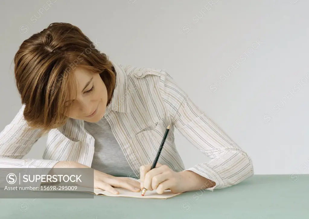 Young woman with notebook, erasing