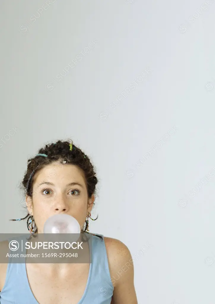 Young woman blowing bubble gum bubble, portrait