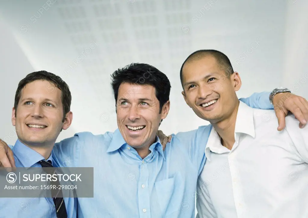 Three businessmen with arms around each others´ shoulders