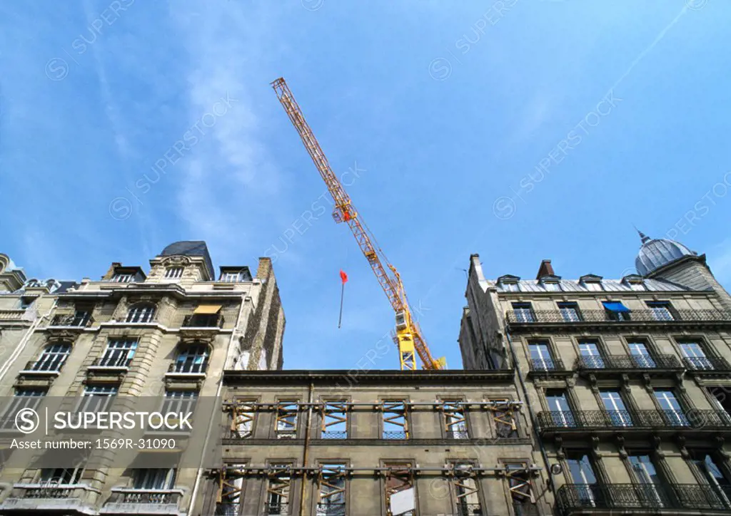 Building facades with crane, low angle view